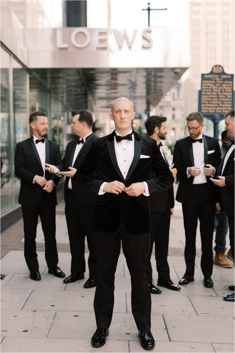groom and groomsmen pose by hotel entrance in Philly