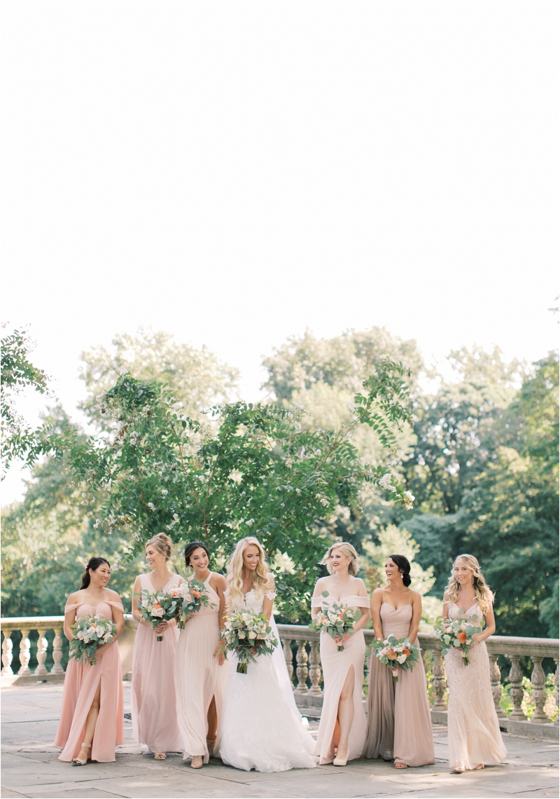 bride poses with bridesmaids on balcony at Curtis Arboretum