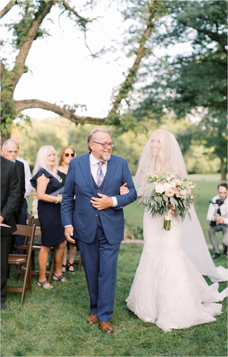 bride walks down the aisle with father at Curtis Arboretum