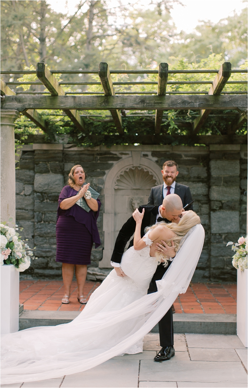 groom kisses bride during Curtis Arboretum ceremony