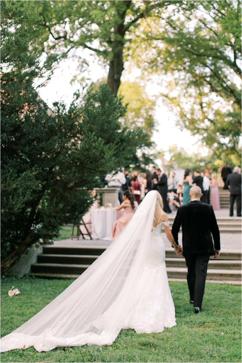 bride and groom walk towards reception on patio at Curtis Arboretum