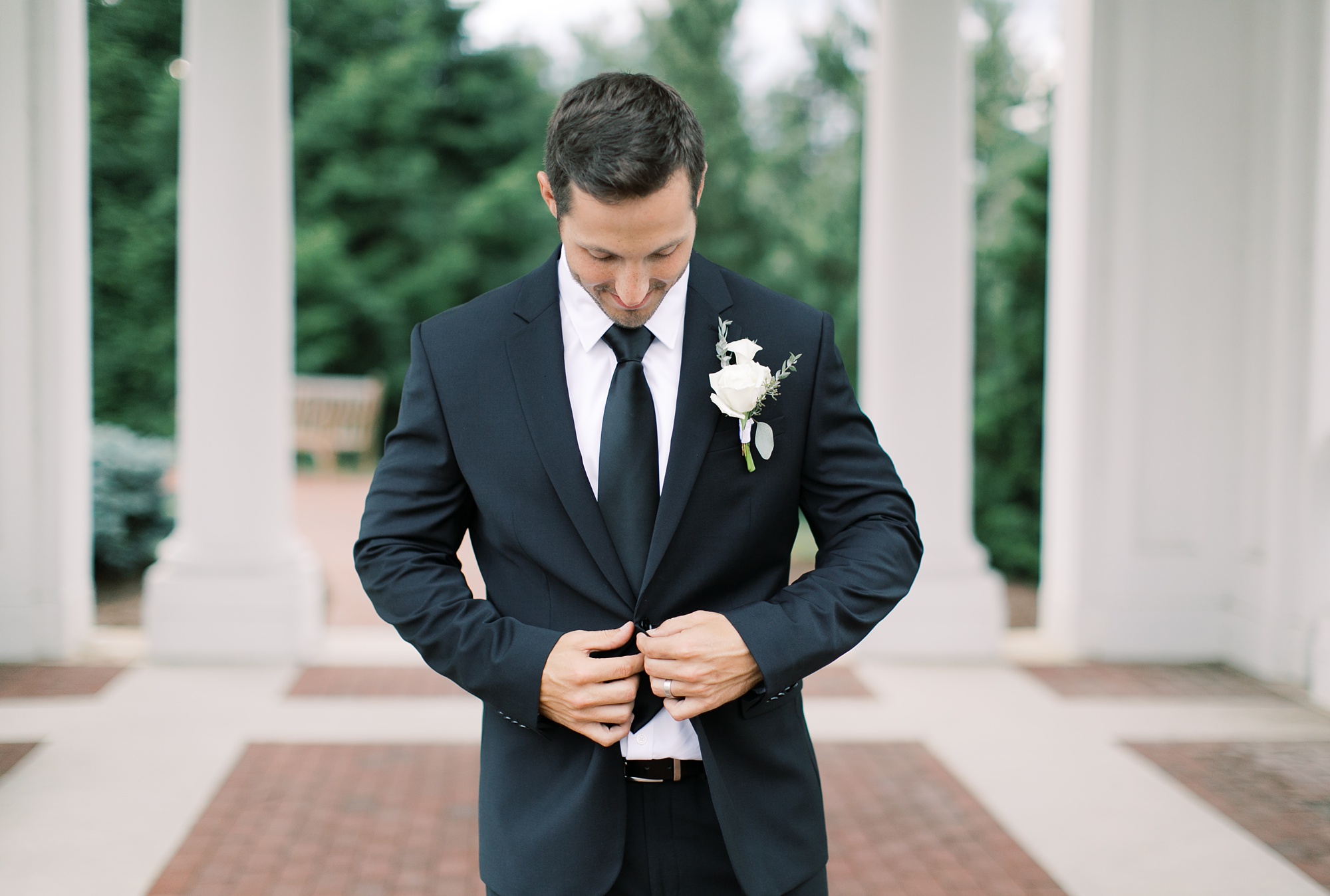 husband adjusts suit jacket during anniversary photos in PA