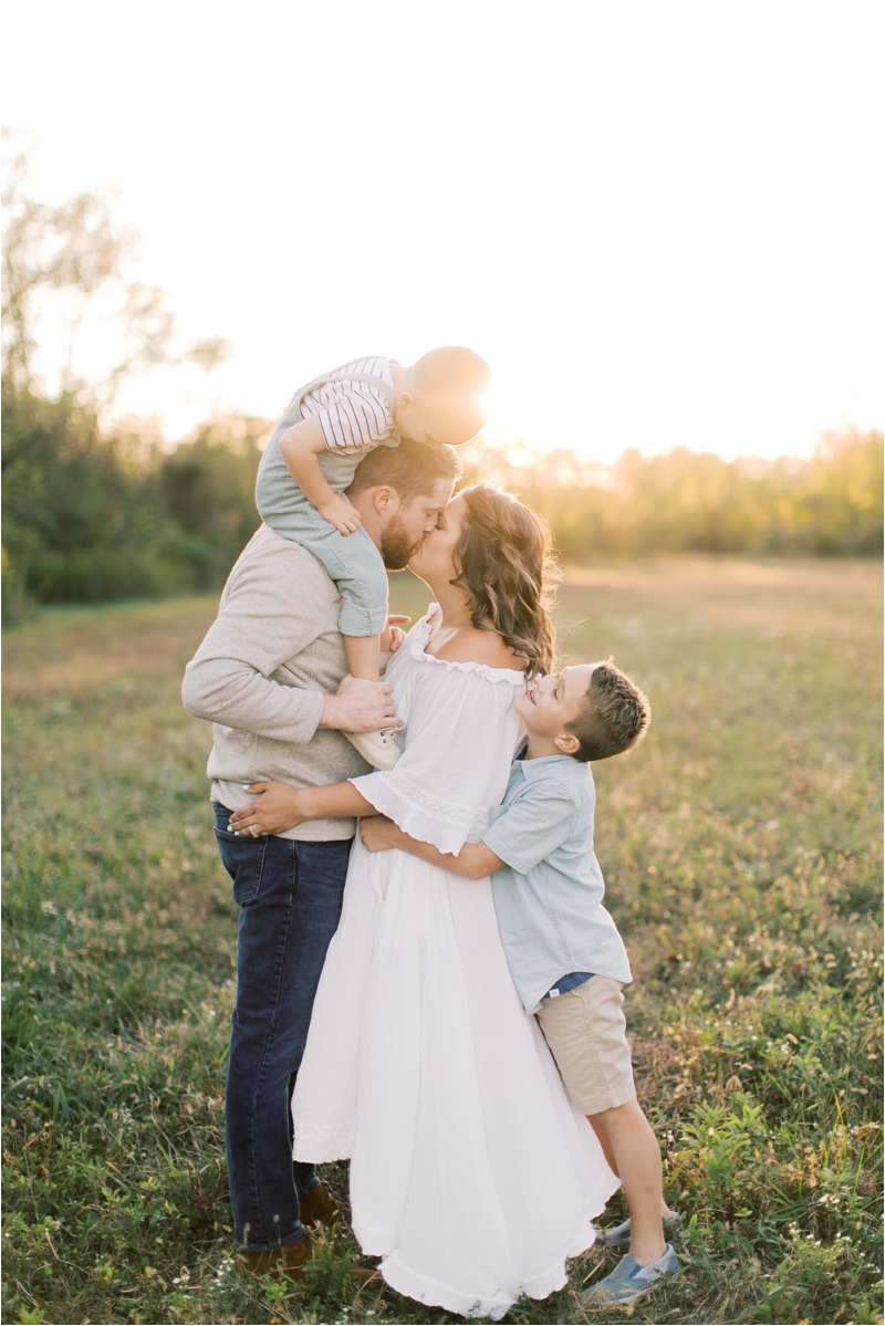 parents kiss during sunset farm family photos with Brianna Wilbur
