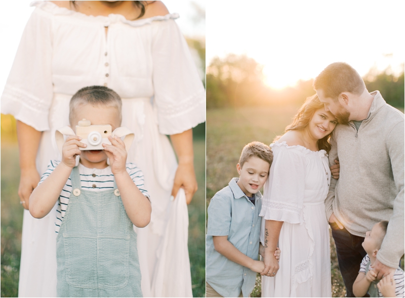 toddler plays with wooden camera during farm family photos