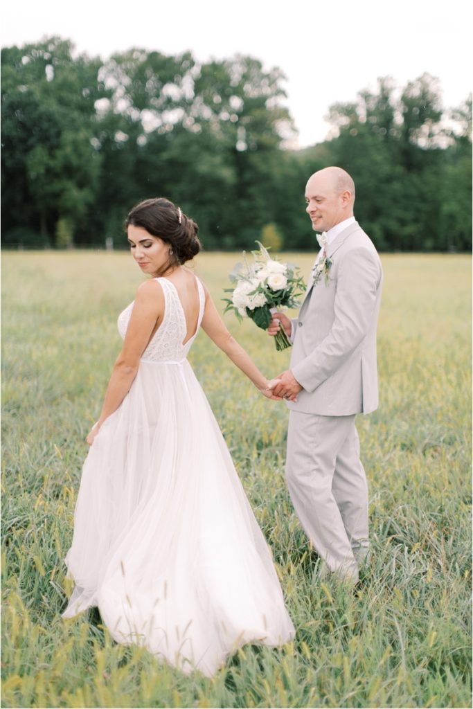 PA couple walks through field on wedding day at Ironstone Ranch