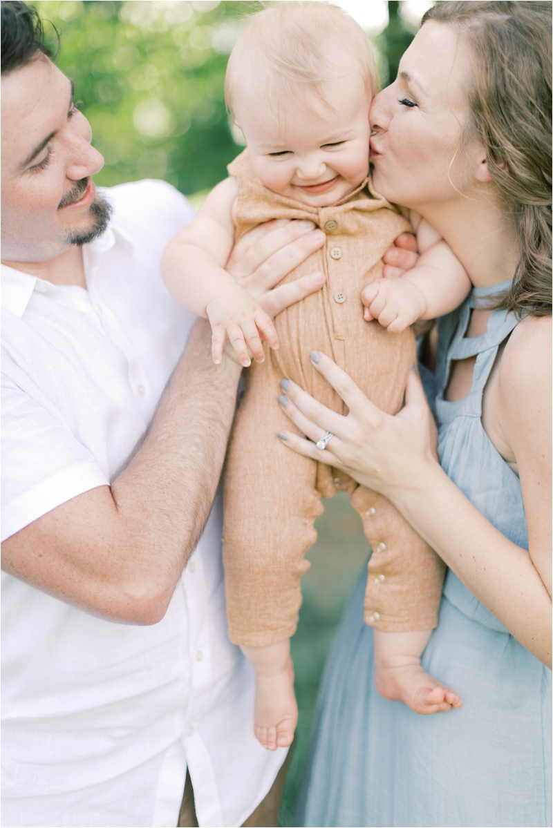parents kiss baby boy during Whispering Oaks Vineyard Family Session