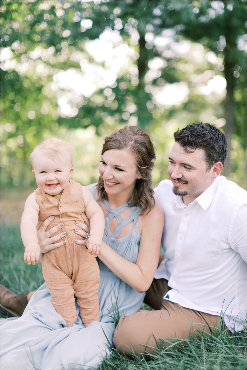 parents laugh with baby boy during PA family photos