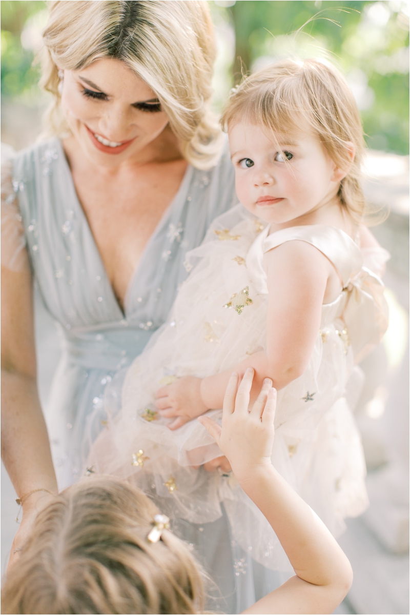 mom holds toddler in pastel summer dress