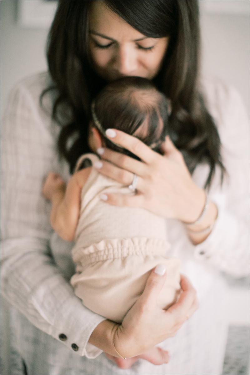 mom holds newborn baby girl on chest during Downtown Lancaster Newborn Session