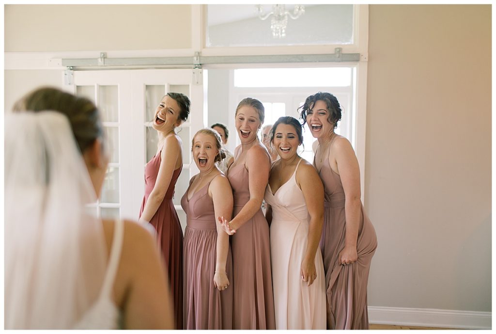 first look as bridesmaids see the bride in her dress