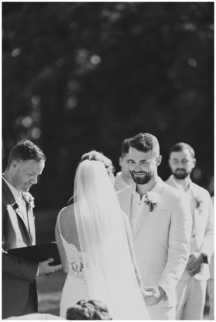 groom smiling at bride during their ceremony